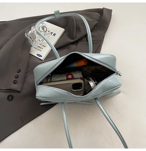 Intérieur spacieux d'un sac en cuir bleu clair montrant le rangement des essentiels