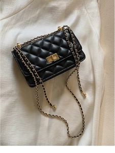 Détail du sac à bandoulière matelassé noir avec fermoir rotatif doré élégant