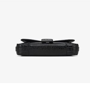 Detailed view of crocodile embossed leather texture and sturdy bottom stitching on black bag