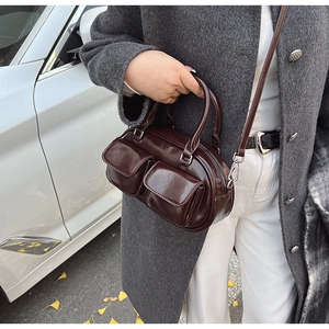 Detail of dark brown vintage oil wax leather handbag with dual front flap pockets