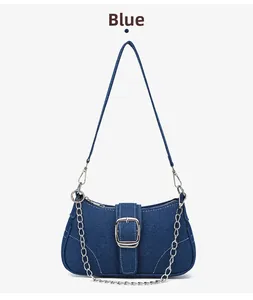 Détail du sac baguette en denim bleu avec boucle carrée argentée et chaîne en métal