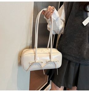 Détail du sac Boston en cuir synthétique blanc crème avec d'élégantes doubles boucles