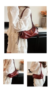 Detail of burgundy leather shoulder bag showing side pleats and sleek glossy finish