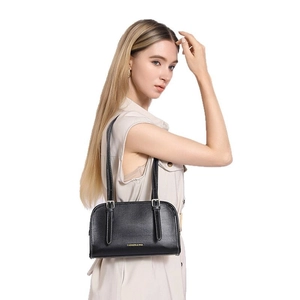 Minimalist black leather underarm bag with gold lettering shown on fashion model