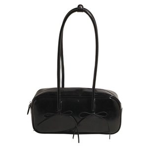 Detail of black patent leather shoulder bag with chic bow accents and zipper closure
