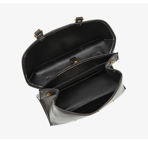 Internal view of the black leather bag showing three compartments and gold hardware snap