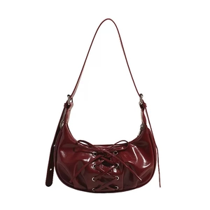 Glossy burgundy half-moon shoulder bag with lace-up details and silver metal eyelets