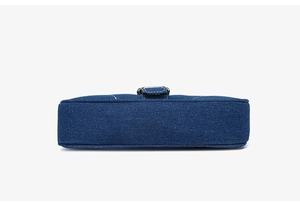 Vue détaillée de la base rectangulaire et des coutures soignées du sac à bandoulière en denim
