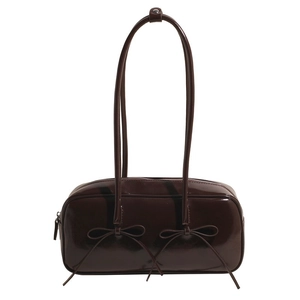 Detail of dark brown patent leather shoulder bag with chic bow accents and glossy finish