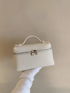 Detailansicht der cremefarbenen Mini-Tasche aus Leder mit Lychee-Narbung und Golddekor
