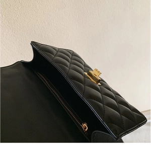 Détail du sac bandoulière en cuir matelassé noir avec fermoir tournant en métal doré