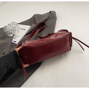 Macro detail of wine red leather texture and rectangular base on a chic shoulder bag