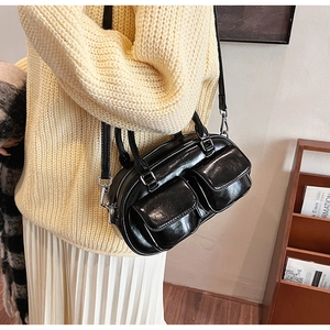 Detail of vintage oil wax leather handbag with double front pockets and adjustable strap