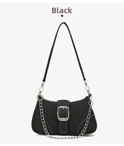 Détail du sac bandoulière en toile noire avec boucle argentée et décor de chaîne
