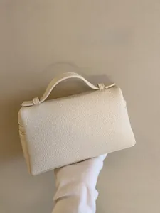 Detail der cremefarbenen Lychee-Lederstruktur einer minimalistischen Damenhandtasche