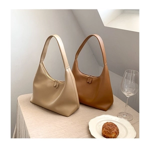Minimalistische Hobo-Taschen aus Leder in Apricot und Braun in einem Lifestyle-Set