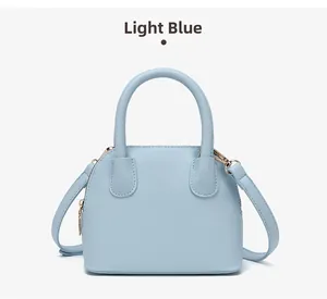 Close-up of light blue shell bag featuring fine lychee grain leather and gold hardware