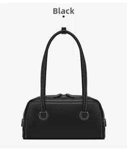 Detail of black matte leather shoulder bag with white contrast stitching and zippers