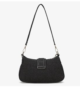 Détail du sac baguette en jean noir avec surpiqûres blanches et garnitures argentées