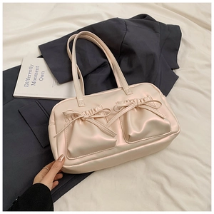 Detailansicht der cremefarbenen Schultertasche aus Kunstleder mit Schleifentaschen und Textur