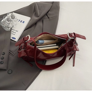 Internal storage detail of vintage red faux leather shoulder bag with daily essentials
