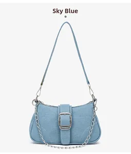 Détail du sac bandoulière en denim bleu ciel avec chaîne argentée et boucle en métal