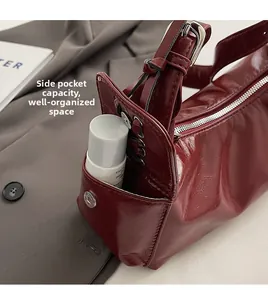 Detail of red glossy leather shoulder bag side pocket with metal magnetic buckle closure