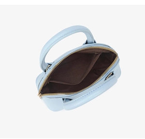 Close-up of light blue shell bag interior with brown fabric lining and open pocket
