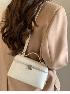 Detail der weißen Schminkkoffertasche mit Litschi-Muster, Silberreißverschlüssen und Griff