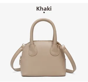 Detail of khaki shell-shaped handbag with pebbled texture and adjustable shoulder strap