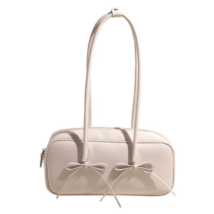 Détail du sac à bandoulière crème avec nœuds élégants et fermeture éclair fluide