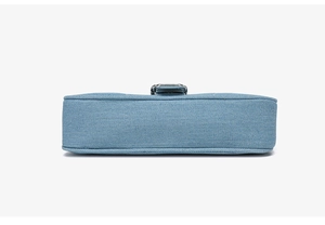 Vue détaillée du fond d'un sac bandoulière en denim bleu clair avec coutures et texture