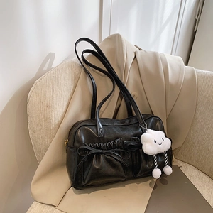 Details der schwarzen Schultertasche mit Rüschentaschen und Wolkenanhänger