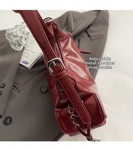 Close-up of vintage dark red shoulder bag with glossy leather and silver metal buckle