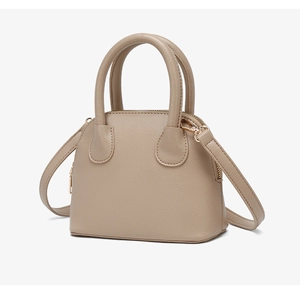 Detail view of lychee grain leather handbag with dual handles and gold zipper hardware