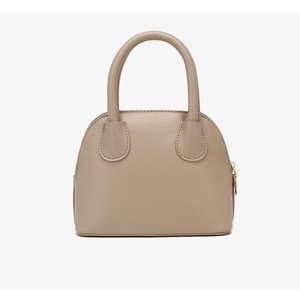 Detail of light brown shell-shaped handbag with premium litchi grain leather texture