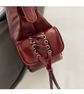 Detailed view of the vintage red leather bag side laces and bronze metal eyelets