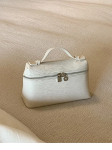 Detail der cremeweißen Handtasche aus Narbenleder mit silbernen Doppelreißverschlüssen