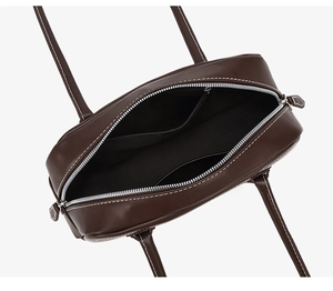 Interior view of dark brown leather Boston bag showing pockets and silver zipper detail