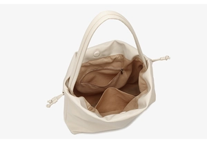 Details der cremefarbenen Beuteltasche mit braunem Futter und Innentaschen