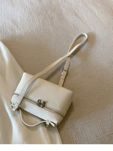 Detail der cremefarbenen Box-Tasche mit Litschistruktur, Reißverschluss und Griff