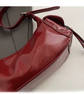 Close-up of vintage deep red soft leather texture on a stylish commuter shoulder bag