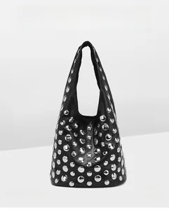 Detail of black leather tote with silver rivets and studs in a modern punk style