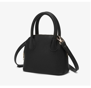 Detail of black lychee grain shell bag with gold hardware and detachable shoulder strap