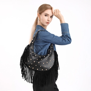 Retro black leather fringe hobo bag with gold rivets and tassels on white background