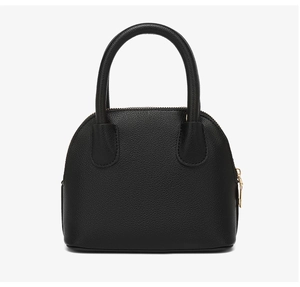 Close-up of black pebble grain shell bag showing round handles and gold zipper detail