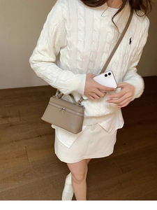 Umhängetasche aus Leder mit Litschimuster am Modell in Khaki mit silbernem Reißverschluss