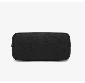 Close-up of the pebbled leather base and fine stitching on a black shell bag