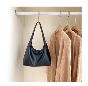 Minimalistische schwarze matte Hobo-Umhängetasche in einer sauberen Garderobe präsentiert
