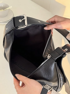 Detailed top view of a black leather tote bag with silver zipper and spacious interior